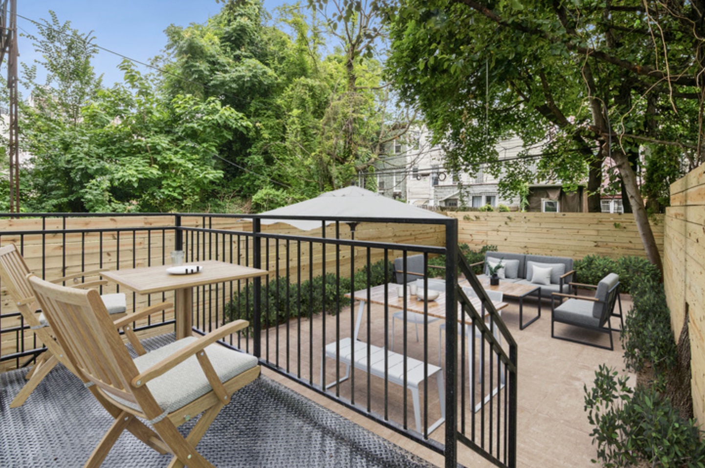 Landscaped Brooklyn backyard with wood deck, dining set, and lounge seating