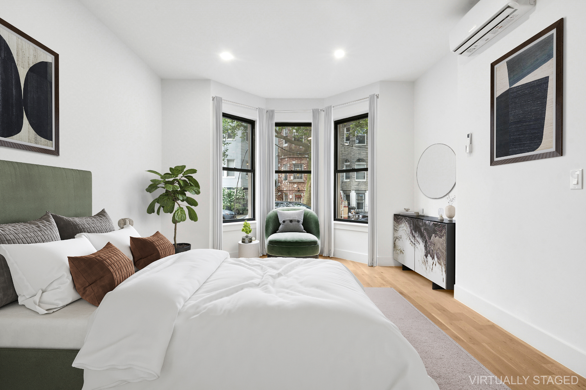 Bright bedroom with bay window and green velvet accent chair