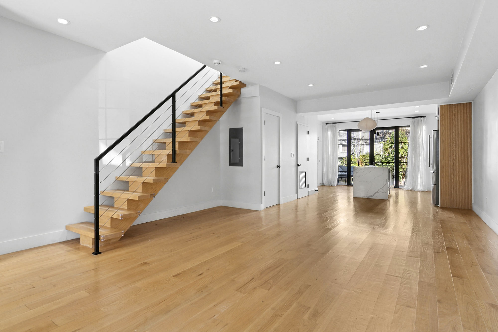 Open floor plan with floating oak staircase and marble kitchen island