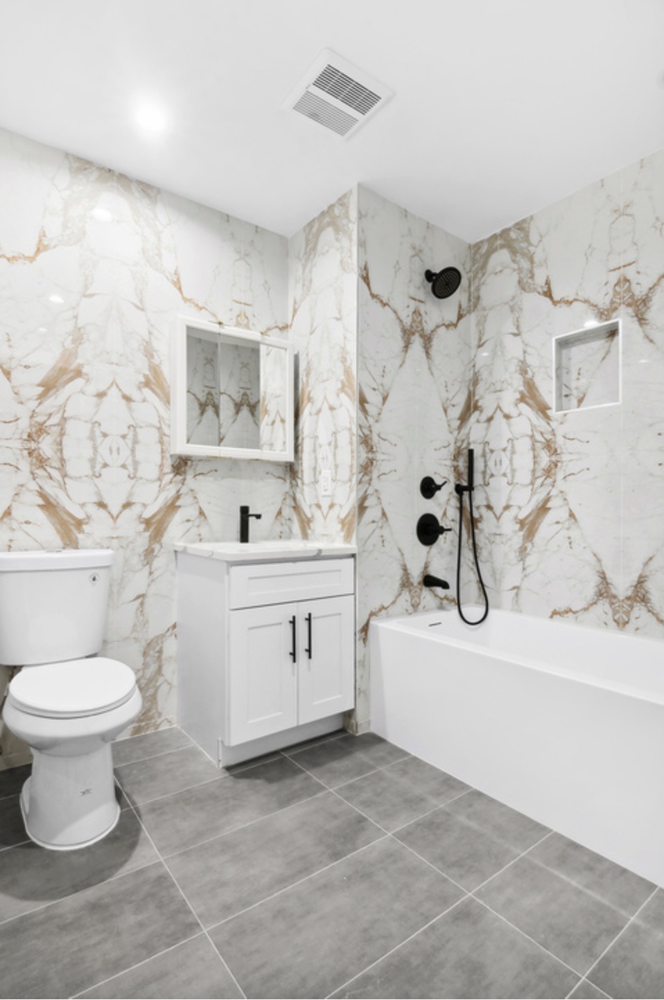 Turnover-ready bathroom at 119 Woodbine with book-matched marble and matte black fixtures